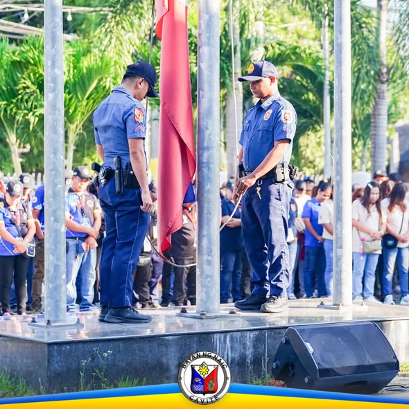 Mga uniformadong pulis habang itinataas ang watawat sa flag raising ceremony sa Bayan ng Naic, Humbac