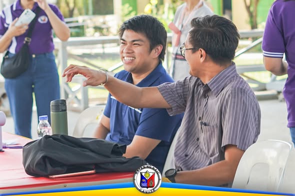 Dalawang lalaki na nakaupo sa outdoor na programa ng career guidance para sa mga Grade 10 sa Naic