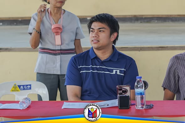 Lalaking naka-navy polo habang nakaupo sa mesa sa programa ng career guidance sa Centro de Naic NHS
