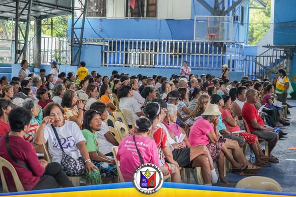 Mga dumalo na nakaupo sa covered court habang nakikinig sa PhilHealth YAKAP para sa Manggagawa, Timalan Concepcion