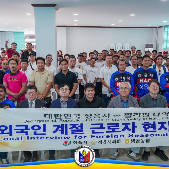 Grupo ng mga kalahok at opisyal na may hawak na banner ng Local Interview for Foreign Seasonal Workers sa Naic, Cavite