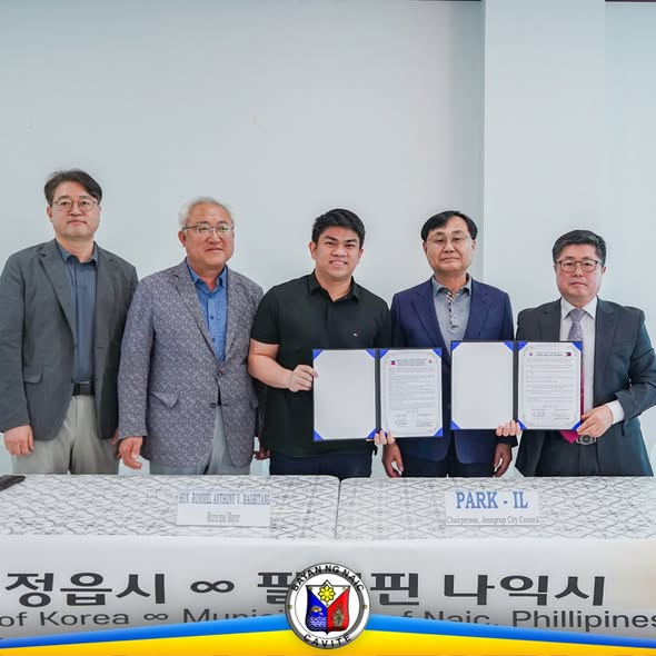 Pormal na pagpirma ng MOU ng Naic at Jeongeup-si, Korea; limang lalaking nakatayo habang hawak ang mga dokumento