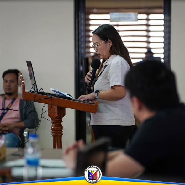 Babaeng nagsasalita sa mikropono sa podium habang nagpupulong sa ABC Hall, Naic