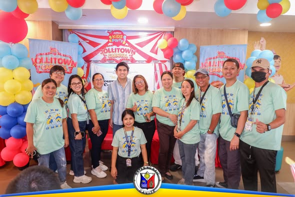 Grupo ng mga kalahok na naka-teal na t-shirt habang nagpo-pose sa Jollitown Carnival sa Jollibee Highway, Naic
