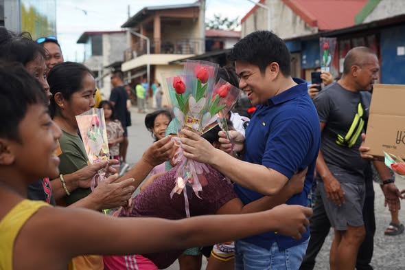 Namimigay ng bulaklak na tulips ang isang opisyal sa mga residente sa kalsada tuwing Araw ng mga Puso