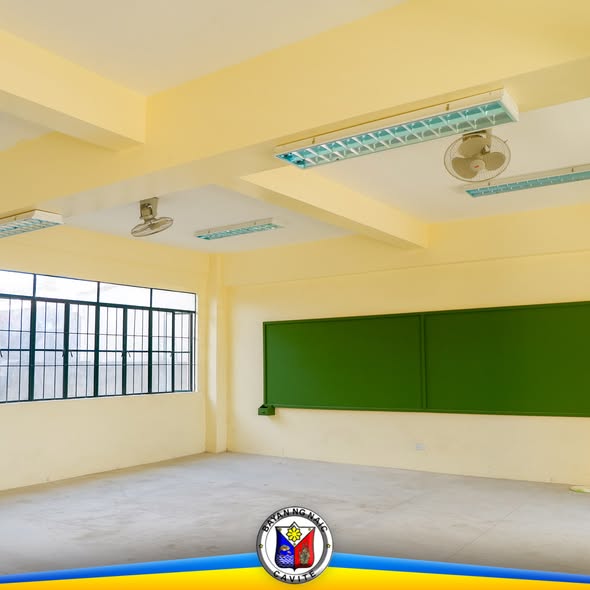 Walang laman na silid-aralan na may berdeng pisara at mga bintanang may rehas sa Timalan Hillsview Integrated School Annex