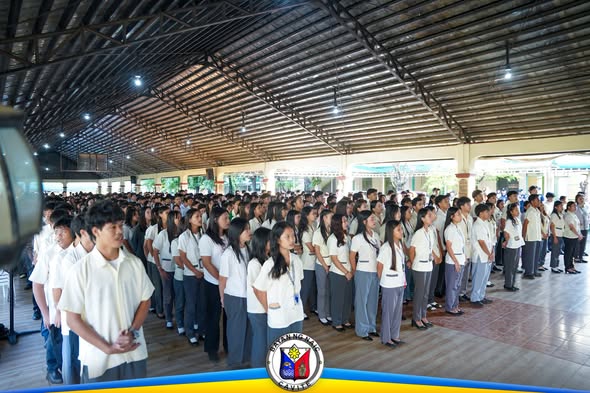Mga mag-aaral na nakatayo sa flag ceremony sa Naic Integrated National High School