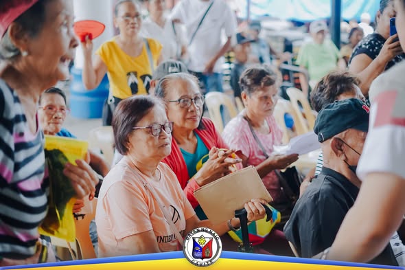 Mga senior citizen na nakaupo at naghihintay sa Social Pension Distribution sa Naic Town Plaza