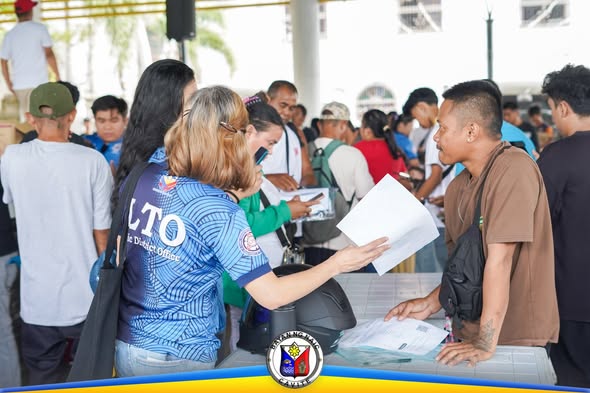Mga tauhan ng LTO na nagseserbisyo sa mga aplikante sa LTO Caravan sa Naic Town Plaza