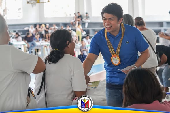 Isang opisyal na nakikipagkamay sa isang benepisyaryo ng 4Ps sa Pugay-Tagumpay Ceremony sa Naic Covered Court