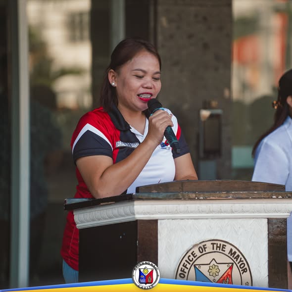 Babaeng nagsasalita sa mikropono sa podium ng Office of the Mayor sa Naic Municipal Hall