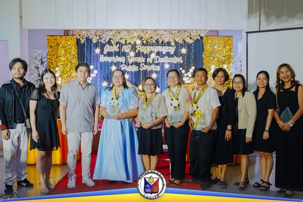 Grupo ng mga retiradong kawani na may hawak na parangal sa Retirees Night 2026 sa Naic