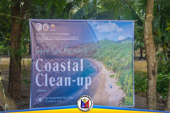 Poster: Coastal Clean-up sa Brgy. Bucana Malaki, Naic, Cavite, Oktubre 14, 2026, nakasabit sa pagitan ng mga puno