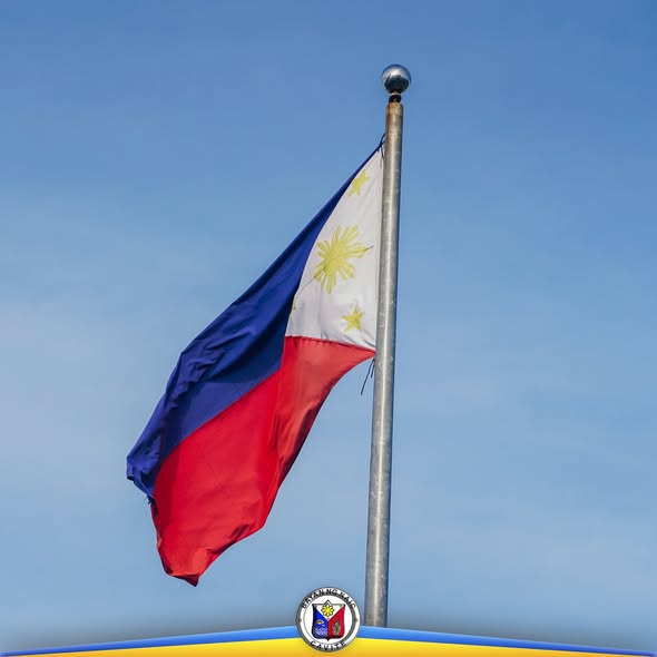 Watawat ng Pilipinas na nakawagayway sa poste sa ilalim ng asul na langit, sa Naic Municipal Hall