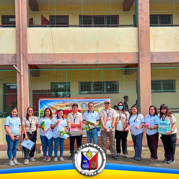 Grupo ng MDRRMO staff na namimigay ng first aid supplies at hygiene kits sa harap ng paaralan