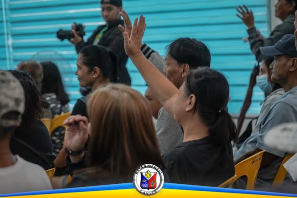 Mga tao sa upuan na nagtataas ng kamay sa Free Pustiso Project sa Triple 8, Sabang, Naic