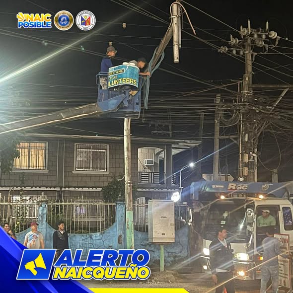 Mga manggagawa sa bucket lift na nag-aayos ng kable sa poste sa San Roque, gabi