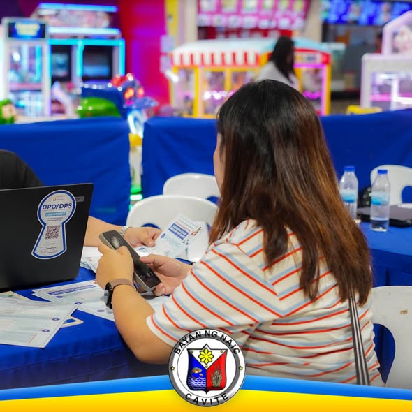 Babaeng nag-aasikaso ng papeles at telepono sa registration table ng SSS at TIN sa Waltermart, Sabang, Naic