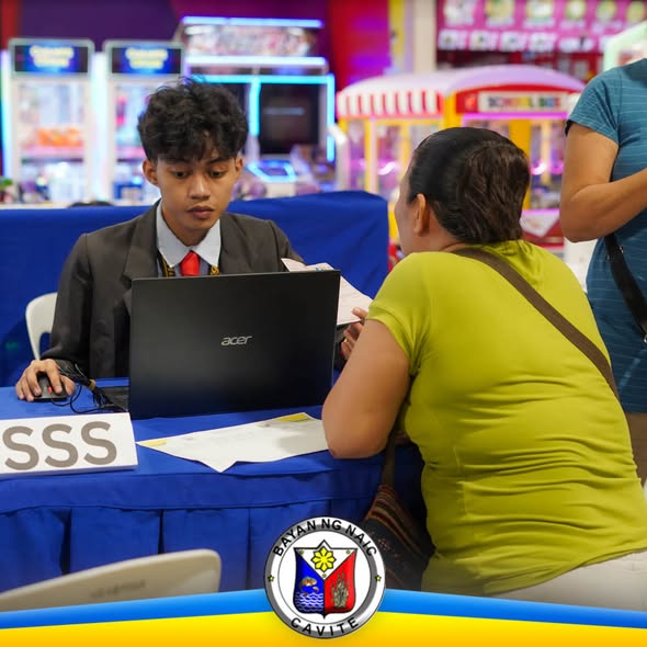 Staff ng SSS na tumutulong sa residente sa registration sa Waltermart, Sabang, Naic