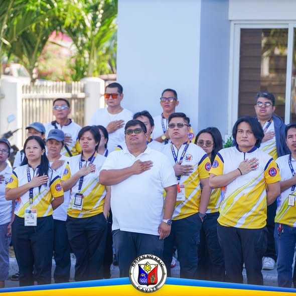 Mga kawani habang nagpupugay sa watawat sa flag raising ceremony sa Naic Municipal Hall
