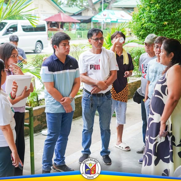 Mga tao sa labas ng paaralan habang nag-uusap at nakikinig sa pamamahagi ng school supplies