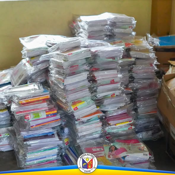 Mga tambak ng notebook at school supplies na nakabalot sa plastik, naka-imbak para sa libreng pamamahagi