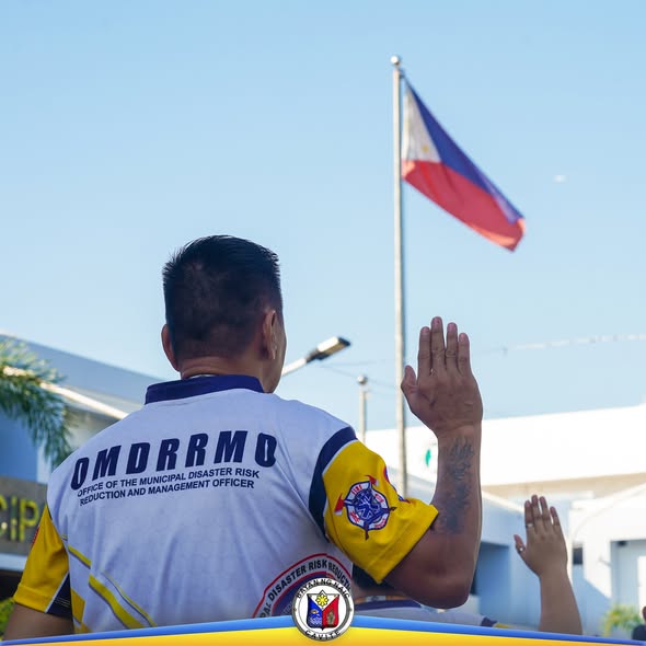 Tauhan ng OMDRRMO na nagsaludo habang nakataas ang watawat ng Pilipinas sa flag raising ceremony sa Naic