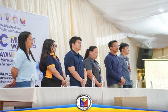 Mga kalahok na nakatayo sa harap ng mesa sa Naic Migrant Workers Day, Hunyo 19, 2026