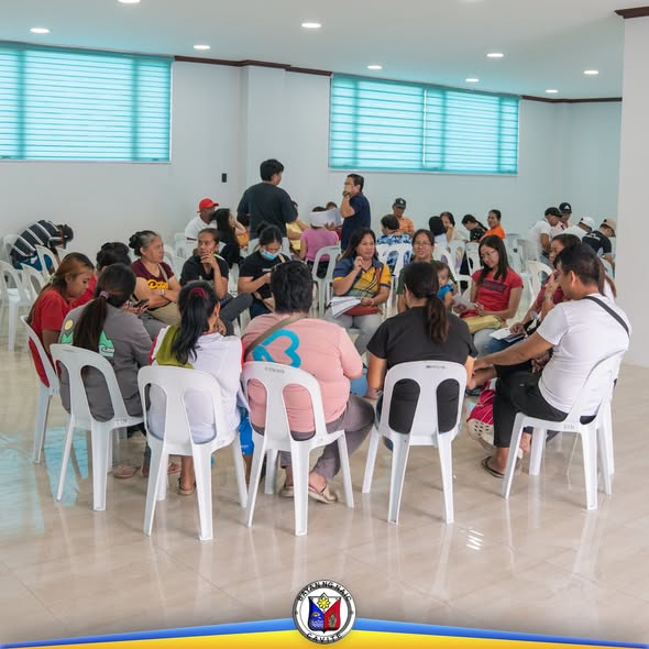 Mga benepisyaryo ng SLP na nakaupo sa bilog habang nakikinig sa financial education session sa loob ng hall