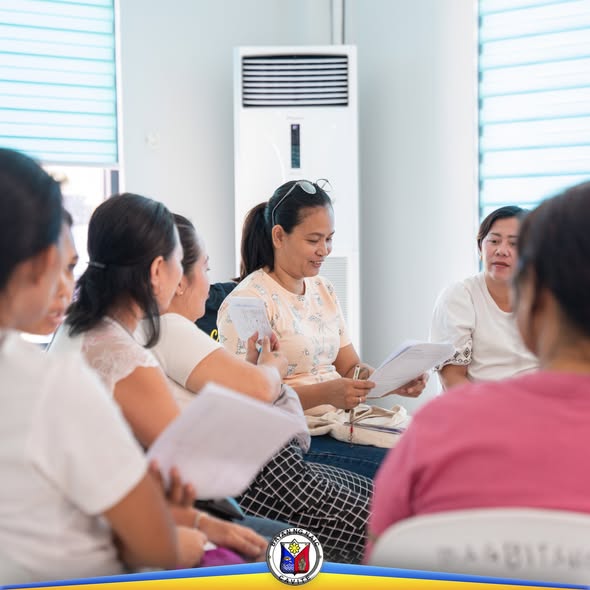 Mga benepisyaryo ng SLP habang nagbabasa at nag-uusap sa Financial Education Session sa Naic