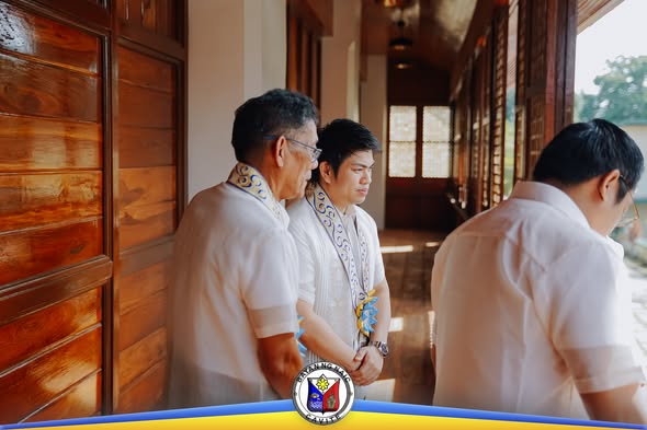 Mga kalalakihan na naka-barong habang nakatayo sa pasilyo ng Casa Hacienda de Naic