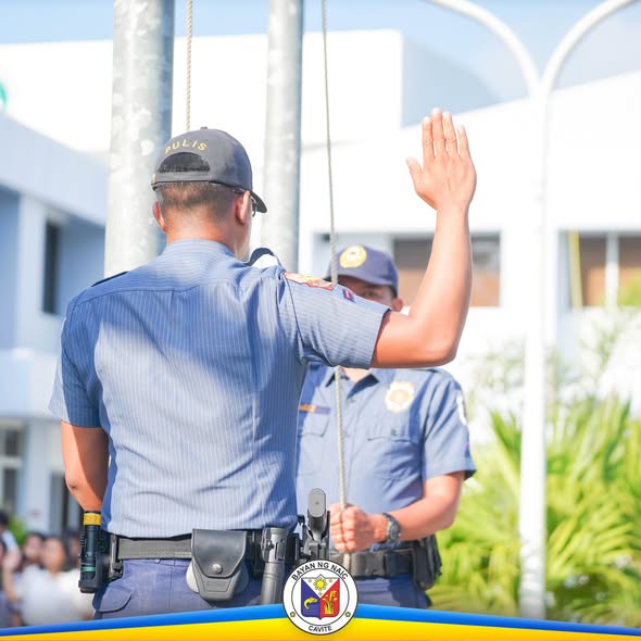 Mga pulis na nagtataas ng kamay sa flag raising ceremony sa Naic, Cavite
