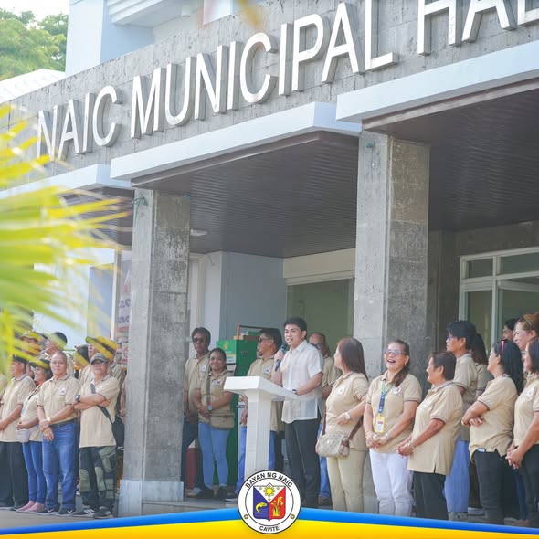 Flag raising ceremony sa Naic Municipal Hall, may nagsasalita sa podium at mga kawani na naka-khaki na uniporme