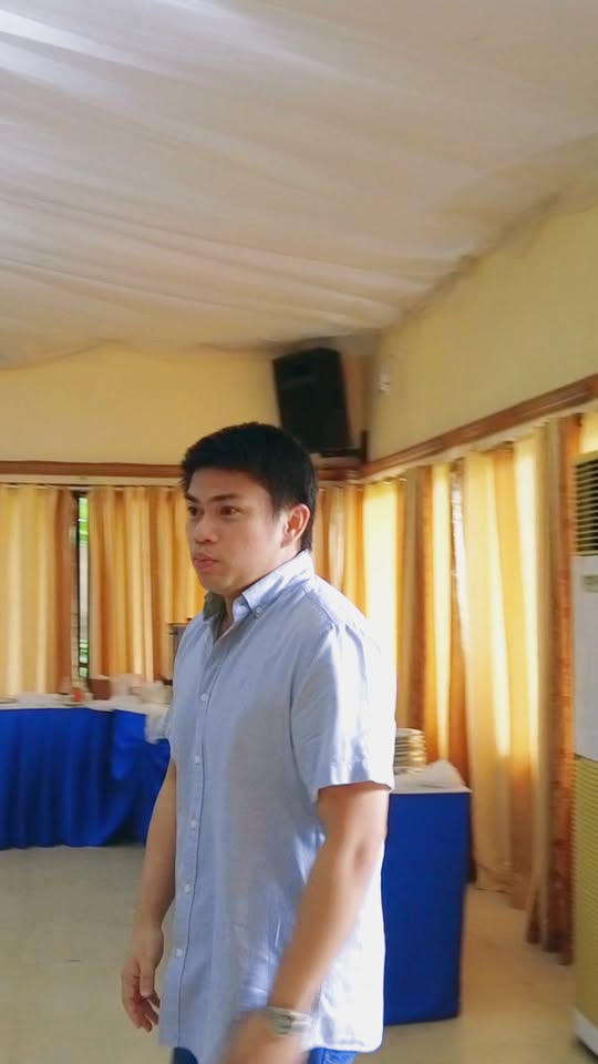Lalaking naka-asul na polo habang naglalakad sa loob ng hall ng Daluyan Community Center, Naic