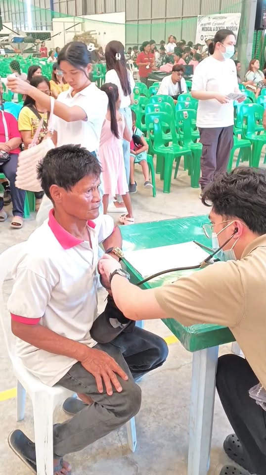 Nagpapasuri ng presyon ng dugo ang isang lalaki sa medical mission sa Sabang, Naic