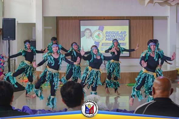 Mga mananayaw na naka-itim at berdeng kasuotan habang nagtatanghal sa entablado ng Regular Monthly Meeting
