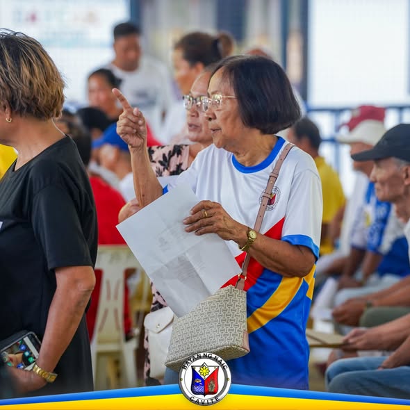 Matandang babae na nakataas ang daliri habang may hawak na papel sa Localized Social Pension, Timalan Balsahan