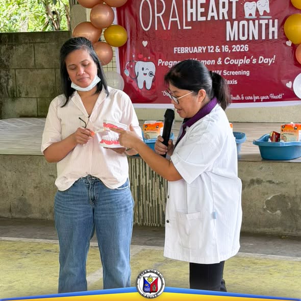 Health worker na nagpapaliwanag gamit ang dental model sa Oral-Heart Month Couple's Day