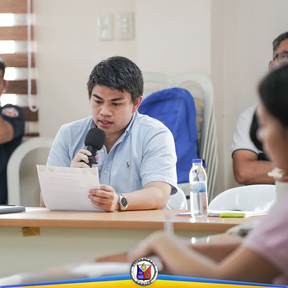Litrato: Lalaking nagbabasa ng papel habang nagsasalita sa mikropono sa MPOC meeting sa Naic