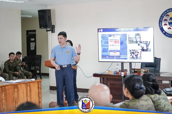 Pulong ng MPOC sa Liga ng mga Barangay, Naic; tagapagsalita habang nagpapakita ng slide tungkol sa 911