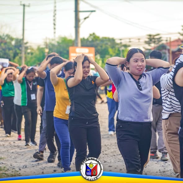 Mga kalahok sa earthquake drill na naglalakad sa kalsada habang nakalagay ang mga kamay sa ulo, Naic, Cavite