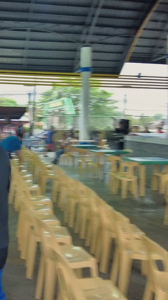 Mga upuang plastik na nakahanay sa covered court ng Naic Town Plaza habang may pamamahagi ng pensyon