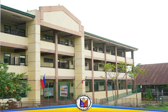 Gusali ng paaralan na may watawat ng Pilipinas sa harap, walang tao sa larawan