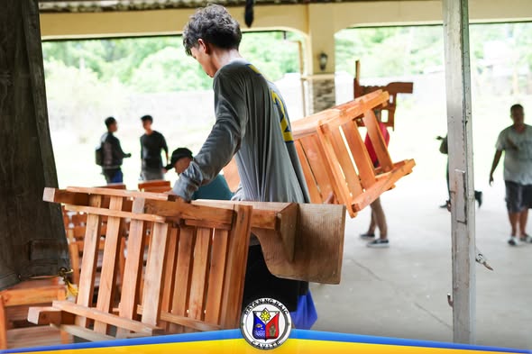 Mga estudyanteng nagbubuhat ng mga upuang kahoy para sa mga paaralan sa Naic, Cavite