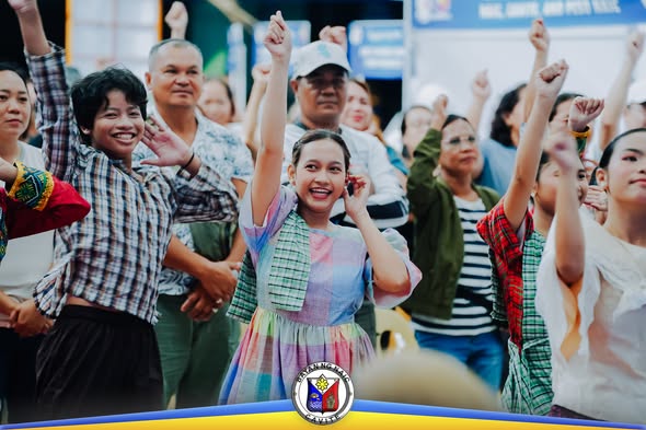 Mga tao na nakataas ang kamay habang nagdiriwang sa pirmahan ng MOA sa Stadium Shopping Strip, Naic
