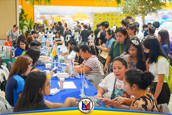 Maraming tao sa job fair sa Waltermart Naic habang nagpaparehistro at nag-aasikaso sa mga mesa