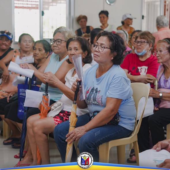 Mga senior citizen na nakaupo sa hall habang naghihintay sa Localized Social Pension sa Barangay Mabolo