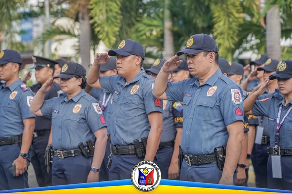 Mga uniporme na tauhan na nagsaludo habang nasa flag raising ceremony sa Naic Municipal Hall