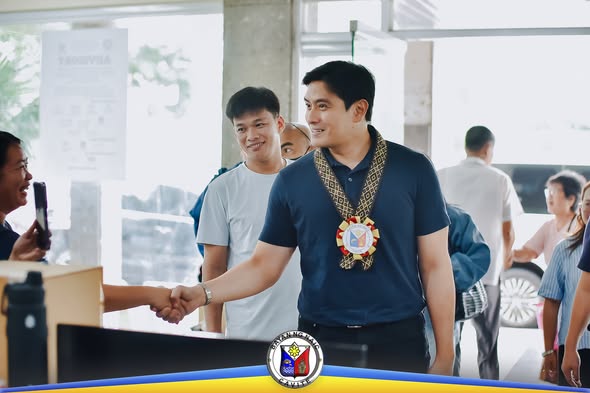 Litrato: Lalaking naka-navy polo at medalyon na nakikipagkamay sa loob ng lobby ng opisina sa Naic