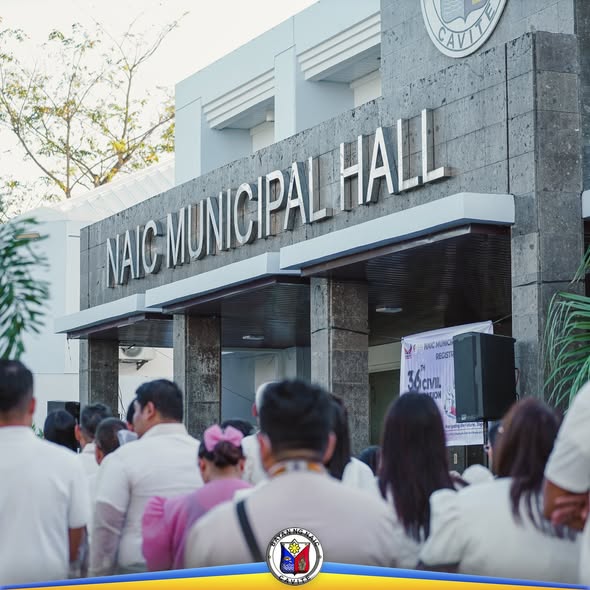 Mga tao sa harap ng Naic Municipal Hall habang nagtitipon para sa flagraising ceremony at Civil Registration Month
